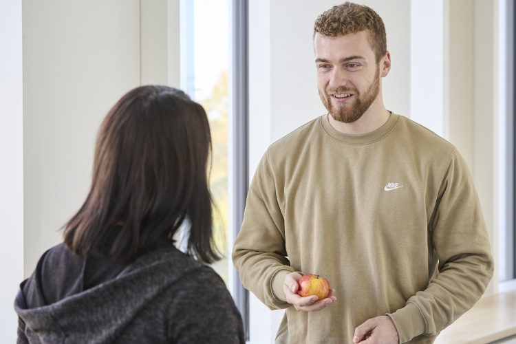 Dirk Weber hält einen Apfel und spricht mit Gabi Zachmann.