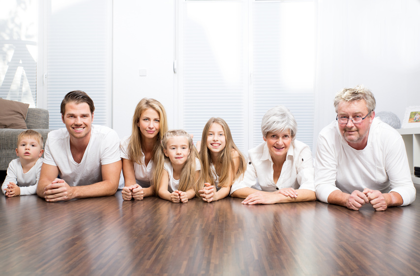 Eine Familie liegt lächelnd auf dem Boden.