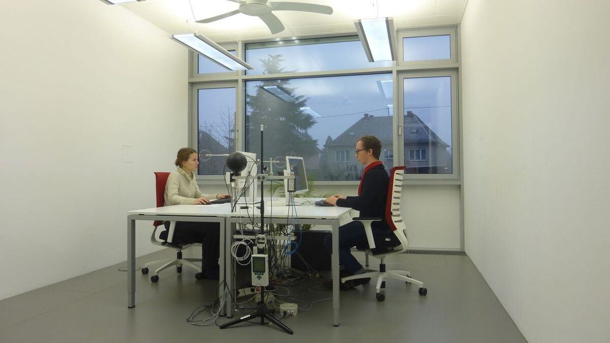 Energieeffizienzmessung mit zwei Personen, die am Schreibtisch vor ihren Monitoren sitzen.