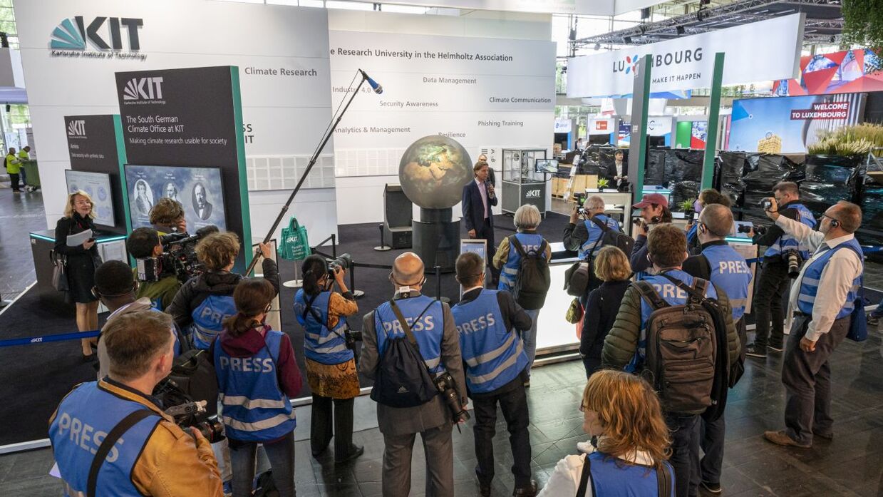 Journalistinnen und Journalisten am Stand des KIT