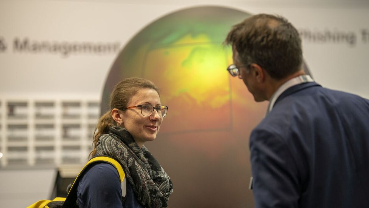  Ein Wissenschaftler des KIT und eine Besucherin am Klimaglobus im Future Hub